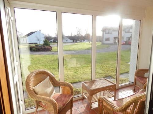 a screened in porch with chairs and a table at Macdonald Spey Valley Resort in Aviemore
