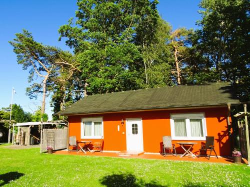una piccola casa arancione con sedie in cortile di Kölp - Gentz H a Kölpinsee auf Usedom