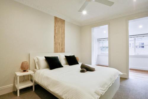 1 dormitorio con 1 cama blanca y 2 ventanas en Vibrant 3 Bedroom House Darlinghurst 2 E-Bikes Included en Sídney
