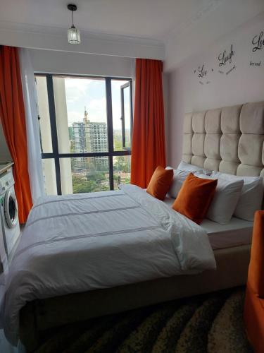 Cama grande en habitación con ventana grande en Studio apartment, Smarthomes, en Nairobi