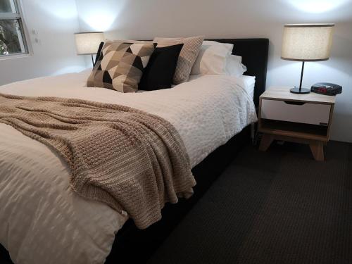 a bedroom with a bed and a night stand with a lamp at Harbourside7 - modern 1br unit with fab views in Sydney