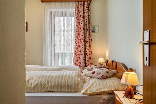 a bedroom with two beds and a window at Appartamento Aurone in Arabba