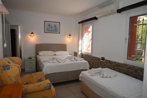 Pokój hotelowy z 2 łóżkami i krzesłem w obiekcie Melis Pansiyon w Bodrum