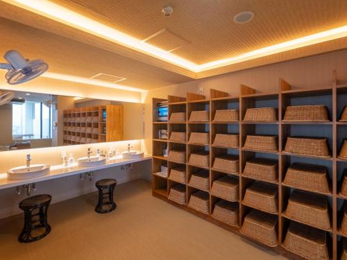 a large bathroom with two sinks and shelves with towels at Mikuma Hotel in Hita