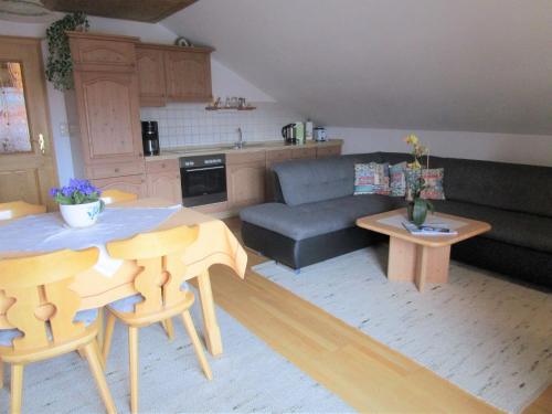 a living room with a couch and a table at Apartment in the Allg u with view of the Bavarian Alps in Bernbeuren