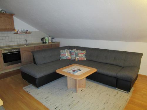 a living room with a couch and a coffee table at Apartment in the Allg u with view of the Bavarian Alps in Bernbeuren