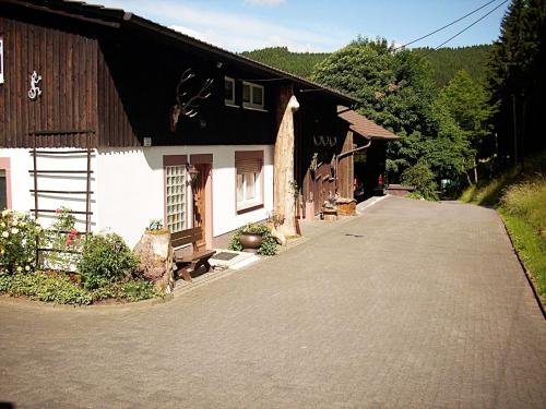 ein Haus mit einer Auffahrt neben einem Gebäude in der Unterkunft Apartment in Bruchhausen right on the fishing river in Oberveischede