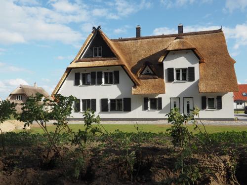Cette grande maison blanche est dotée d'un toit de chaume. dans l'établissement Fairy tale holiday home in Rerik near the centre, à Rerik