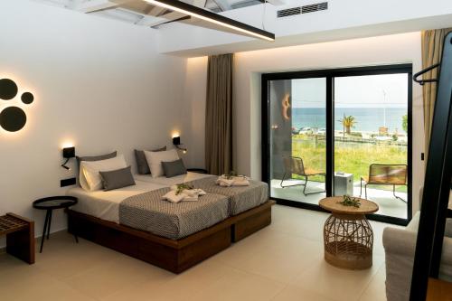 Niki Luxury Apartments Niki Suites Petra في بيترا: غرفة نوم مع سرير وإطلالة على المحيط