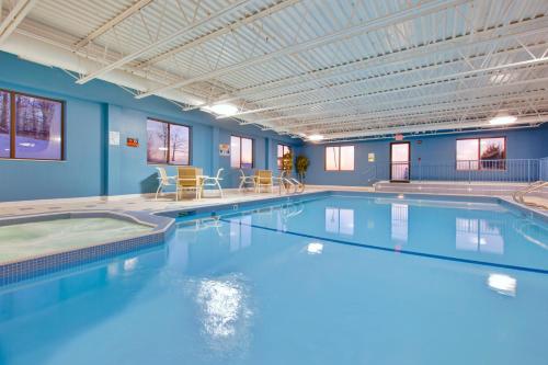 Holiday Inn Express Sault Ste Marie, an IHG Hotel في سولت سانت ماري: مسبح كبير في مبنى به جدران زرقاء