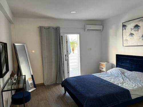 1 dormitorio con 1 cama y puerta corredera de cristal en Lilian apartment, en Ayia Napa