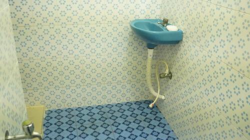 a bathroom with a blue sink on the wall at SS Family Villa in Varkala