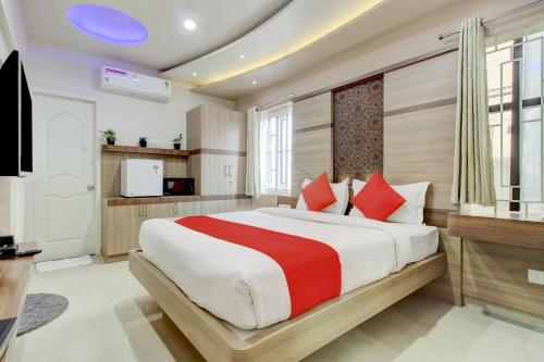 ein Schlafzimmer mit einem großen Bett mit roten Kissen in der Unterkunft OYO OYO Emara Boutique Hotel Nearby Koramangala Forum Mall in Bangalore
