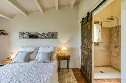 1 dormitorio con cama y ducha en El Pedró Panoramic, en Ventalló
