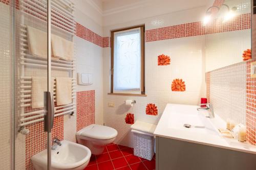 a bathroom with a toilet and a sink and a mirror at Appartamenti My Dream in Malcesine