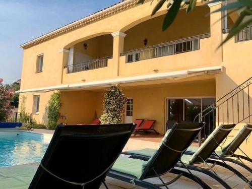 a group of chairs sitting in front of a house at Beautiful Villa in Vidauban with seasonal Pool in Vidauban