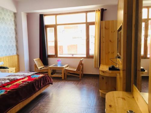 HOTEL CORNER RETREAT BnB في مانالي: غرفة نوم بسرير وطاولة ونافذة