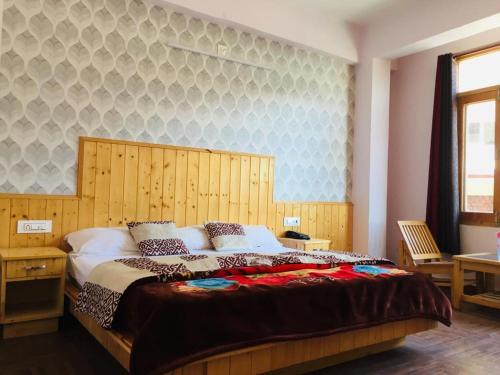 Schlafzimmer mit einem großen Bett mit einem Kopfteil aus Holz in der Unterkunft HOTEL CORNER RETREAT BnB in Manali