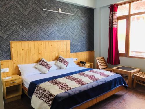 een slaapkamer met een bed met een blauwe patroonmuur bij HOTEL CORNER RETREAT BnB in Manāli