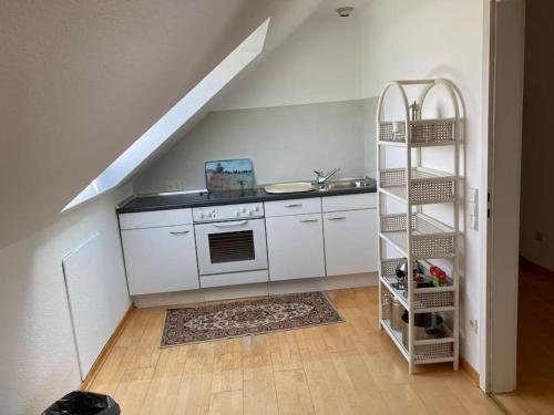 uma cozinha com um fogão e uma escada num quarto em Schönes Dachapartment (2 Schlafzimmer) em Gütersloh
