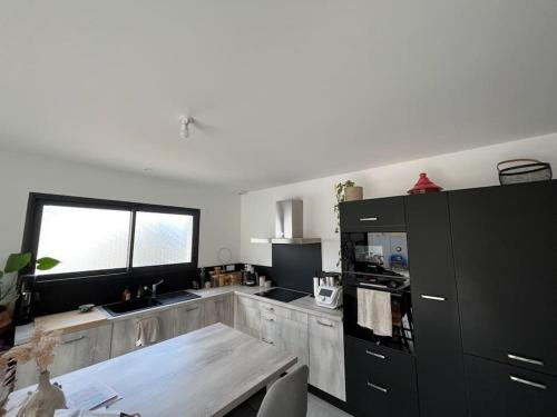 une cuisine avec une table en bois et une fenêtre dans l'établissement Jolie maison avec piscine, à Nissan-lez-Enserune