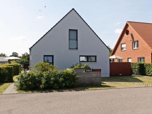 a white house with a red building at Pleasant Holiday Home in Zierow near Sea in Zierow