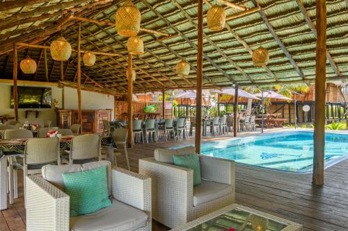 a resort with a pool and tables and chairs at Ocean Pearl Beach Lodge in Vilanculos