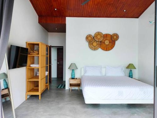 サムイ島にあるChaweng Blue Sky Villa - Partial Ocean Viewのベッドルーム1室(ベッド1台、壁掛け時計付)