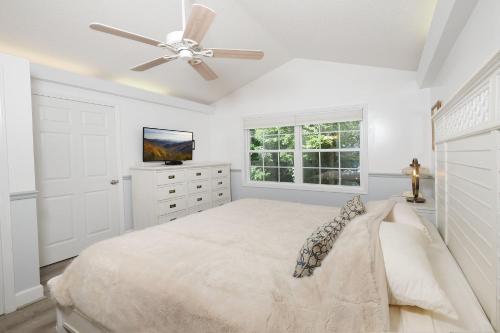 ein weißes Schlafzimmer mit einem Bett und einem Deckenventilator in der Unterkunft Heavens Edge 2016 in Gatlinburg