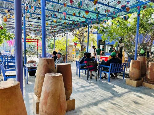 a patio with people sitting at tables and chairs at Ninh Chu 2 Hotel in Phan Rang