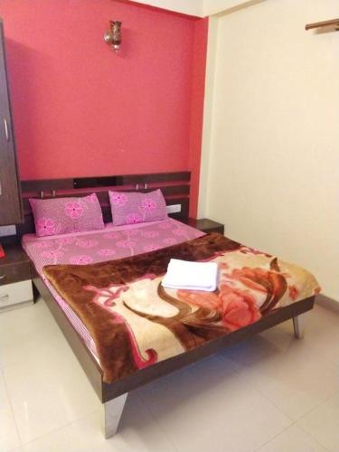 a bed in a room with a pink wall at Panna Palace Guest House in Udaipur