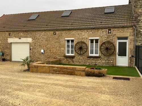 a brick house with a driveway in front of it at L’ÉCURIE in Gigny