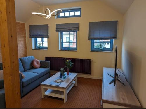 a living room with a couch and a table at Ferienwohnung Zur Kirschallee in Hochkirch
