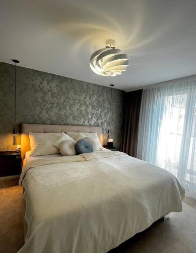 um quarto com uma grande cama branca e uma grande janela em Apartmán Artemis em Košice