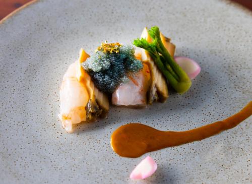 a piece of food with broccoli on a plate with a spoon at ANA InterContinental Appi Kogen Resort by IHG in Hachimantai