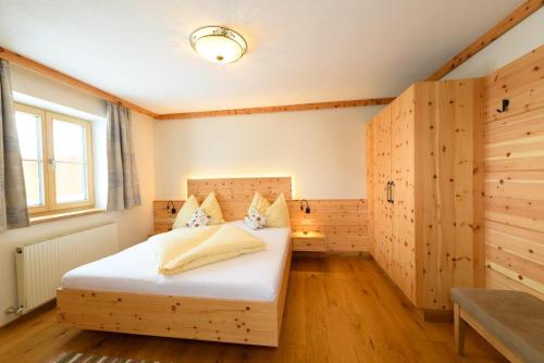 ein Schlafzimmer mit einem Bett in einem Zimmer mit Holzwänden in der Unterkunft Biobauernhof AUBAUER in Großarl