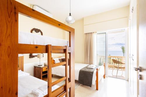 a bedroom with bunk beds with a view of the ocean at Villa Chrysta in Ayios Theodhoros