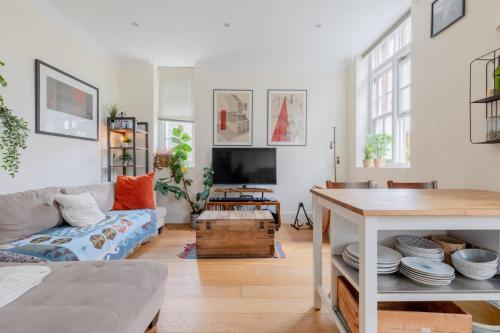 a living room with a couch and a table at Stylish Bohemian 2BD Flat Mile End Park! in London