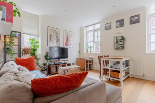a living room with a couch and a tv at Stylish Bohemian 2BD Flat Mile End Park! in London