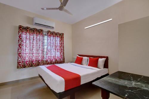 um quarto com uma cama com uma cortina vermelha em OYO Century Park em Kasaragod