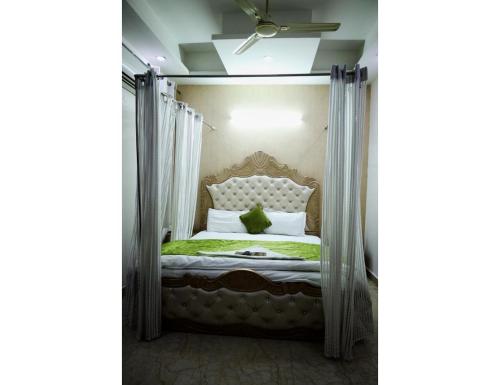 a bedroom with a bed with a canopy at Hotel The Grand Palace, Ghaziabad in Ghaziabad