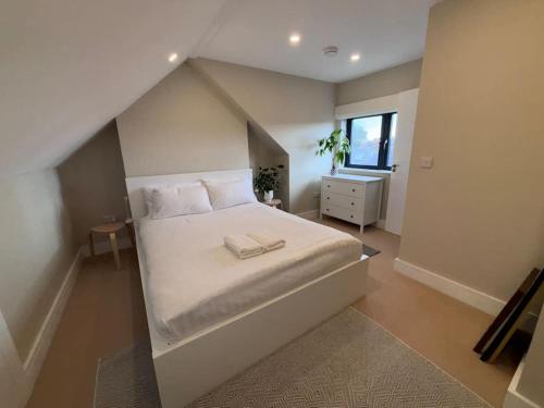 a bedroom with a large bed with white sheets at Splendid South Dublin Ranelagh Townhouse in Dublin
