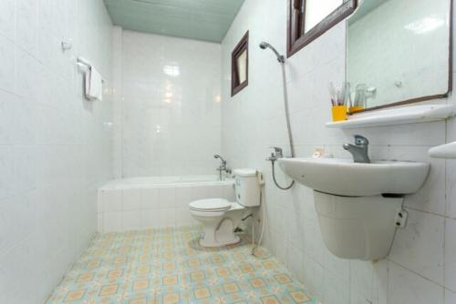 a white bathroom with a sink and a toilet at Cửa Đại Beach Hotel in Hoi An