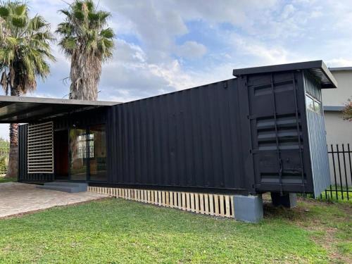 a black house with a black facade at Hagedis Dorp - 1 Bedroom Apartment in Hartbeespoort