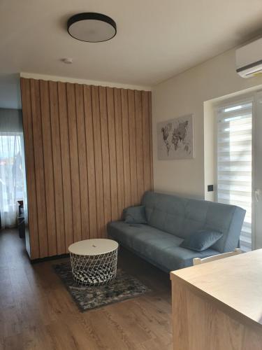 a living room with a blue couch and a table at Žvėrynas Workation apartments in Vilnius