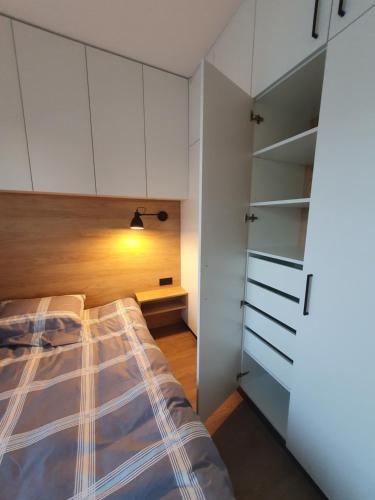 a bedroom with a bed and white cabinets at Žvėrynas Workation apartments in Vilnius