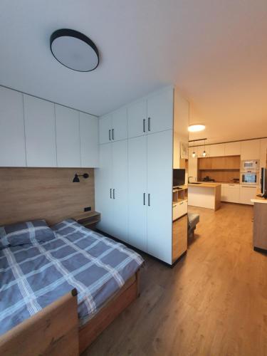 a bedroom with a large bed and a kitchen at Žvėrynas Workation apartments in Vilnius