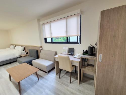 Una habitación de hotel con una cama y un escritorio y una habitación. en 悠而行旅, en Nangan