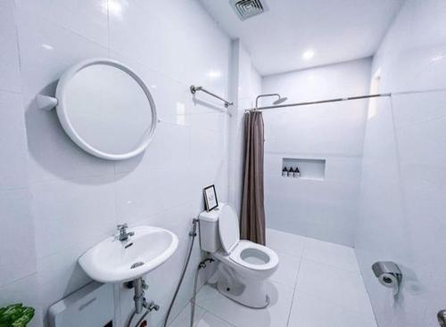 a bathroom with a sink and a toilet and a mirror at Moonlight House Tagaytay in Tagaytay