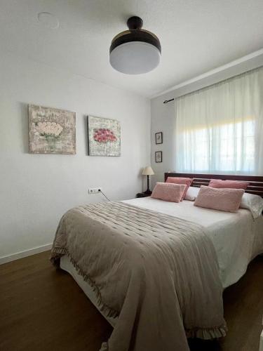 um quarto com uma cama grande e almofadas cor-de-rosa em CASA MALENI em Altea